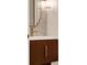 Close-up of a stylish powder room with a wood vanity, gold hardware, and decorative fish scale backsplash at 8665 Pinter St, Orlando, FL 32827
