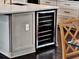 Built-in wine cooler in kitchen island, with shaker cabinets and dining area beyond at 8665 Pinter St, Orlando, FL 32827