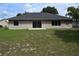 Back exterior features a grassy yard, sliding glass doors, and windows at 910 Amy Ridge Ct, Kissimmee, FL 34747
