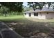 Spacious backyard featuring a large grassy area, concrete patio, and mature trees at 910 Amy Ridge Ct, Kissimmee, FL 34747