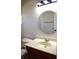 Bathroom featuring a vanity sink with neutral countertop and a round mirror at 910 Amy Ridge Ct, Kissimmee, FL 34747