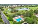 Aerial view featuring a community pool, golf course, and residential area with mature trees at 9376 Se 175Th Pompion St, The Villages, FL 32162