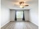 Bright bedroom featuring wood floors, a ceiling fan, and a large window, creating a serene atmosphere at 9376 Se 175Th Pompion St, The Villages, FL 32162