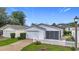 Charming single-story home with a well-manicured lawn, white picket fence, and attached garage at 9376 Se 175Th Pompion St, The Villages, FL 32162