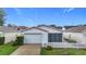 Charming single-story home with a white picket fence, attached garage, and well-maintained front lawn at 9376 Se 175Th Pompion St, The Villages, FL 32162