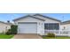 Charming single story home with manicured lawn, white picket fence, attached two car garage, and attractive landscaping at 9376 Se 175Th Pompion St, The Villages, FL 32162