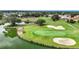 Aerial shot of a golf course featuring a scenic lake with lush green landscapes, sand traps and serene water views at 9376 Se 175Th Pompion St, The Villages, FL 32162
