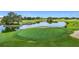 Scenic golf course with lush green fairways, a tranquil pond, and manicured greens, offering a picturesque golfing experience at 9376 Se 175Th Pompion St, The Villages, FL 32162
