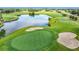 A beautiful golf course view highlighting the green, sand trap, and a serene pond at 9376 Se 175Th Pompion St, The Villages, FL 32162