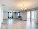 Spacious and bright living room features modern ceiling fan, luxury vinyl plank flooring, and double glass doors at 9376 Se 175Th Pompion St, The Villages, FL 32162