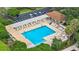 Aerial view of a community pool surrounded by lounge chairs, landscaping, and a covered seating area at 9376 Se 175Th Pompion St, The Villages, FL 32162