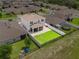 Aerial view of the backyard showcases a large green lawn and screened patio at 944 Benjamin Trl, Davenport, FL 33837