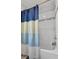 Bathroom with blue striped curtain and white tile tub at 944 Benjamin Trl, Davenport, FL 33837