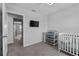 Well-lit bedroom with a crib, changing table, and TV mounted to the wall at 944 Benjamin Trl, Davenport, FL 33837