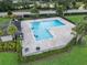 Aerial view of a large community pool surrounded by palm trees and well-manicured landscaping at 944 Benjamin Trl, Davenport, FL 33837