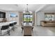 Bright open dining room and kitchen combination with modern light fixtures and sliding glass doors to the patio at 944 Benjamin Trl, Davenport, FL 33837