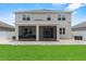 Rear exterior featuring a covered screened patio that walks out to the green backyard at 944 Benjamin Trl, Davenport, FL 33837