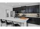 Stylish kitchen with dark wood cabinets, stainless steel appliances, quartz countertop island, and modern backsplash at 944 Benjamin Trl, Davenport, FL 33837