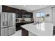 Modern kitchen with stainless steel appliances, quartz countertops and a large island with a view to the backyard at 944 Benjamin Trl, Davenport, FL 33837