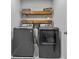 Bright laundry room with wood shelving, and a gray washer and dryer at 944 Benjamin Trl, Davenport, FL 33837