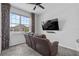 Cozy living room featuring reclining love seat, large window and wall-mounted television at 944 Benjamin Trl, Davenport, FL 33837
