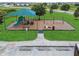 Community playground area with swings, slide and sunshade in a grassy recreational area at 944 Benjamin Trl, Davenport, FL 33837