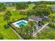 Aerial view of community pool area with cabana, surrounded by tropical landscaping and golf course at 9440 Myrtle Creek Ln # 1003, Orlando, FL 32832