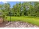 Paver patio leading to a lush backyard with a bird house and mature trees providing privacy at 9440 Myrtle Creek Ln # 1003, Orlando, FL 32832