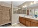Bathroom showcasing a double vanity, tiled shower, and neutral paint at 9440 Myrtle Creek Ln # 1003, Orlando, FL 32832