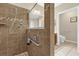 Accessible walk-in shower with grab bars and tiled walls, alongside a separate toilet area at 9440 Myrtle Creek Ln # 1003, Orlando, FL 32832