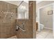 Tiled bathroom featuring a tiled shower with hand-held wand, and a toilet at 9440 Myrtle Creek Ln # 1003, Orlando, FL 32832