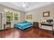 Bright bedroom with tray ceiling, hardwood floors, and large windows with views of nature at 9440 Myrtle Creek Ln # 1003, Orlando, FL 32832