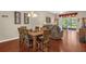 The dining area features a dark wood table set for seven, wood floors, and lots of natural light at 9440 Myrtle Creek Ln # 1003, Orlando, FL 32832