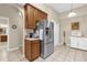 A modern kitchen featuring stainless appliances, wood cabinets, tile flooring, and ample counter space at 9440 Myrtle Creek Ln # 1003, Orlando, FL 32832