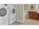 Laundry room with modern washer and dryer units, and view into a bathroom at 9440 Myrtle Creek Ln # 1003, Orlando, FL 32832