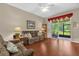 Cozy living room with wood floors, lamps, and a sliding glass door to the patio at 9440 Myrtle Creek Ln # 1003, Orlando, FL 32832