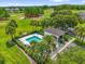 Aerial view of a beautiful community pool with crystal-clear water and tropical landscaping, adjacent to the golf course at 9440 Myrtle Creek Ln # 1003, Orlando, FL 32832