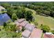 Aerial view of townhomes with tile roofs, mature trees, landscaping, and a water view at 995 Troon Trce, Winter Springs, FL 32708