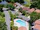 Aerial view of a neighborhood pool surrounded by lush landscaping, townhomes, and a golf course pond at 995 Troon Trce, Winter Springs, FL 32708