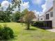 Expansive backyard featuring lush green grass, mature trees, and an enclosed patio at 995 Troon Trce, Winter Springs, FL 32708
