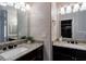 Bathroom featuring dual vanity with granite countertops, large mirrors, and modern lights at 995 Troon Trce, Winter Springs, FL 32708