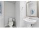 Modern half-bathroom featuring a sleek pedestal sink and minimalist decor at 10009 Randal Walk St, Orlando, FL 32832