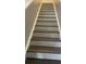 Staircase with painted risers and stained treads leading upstairs at 10604 Savannah Wood Dr # 84, Orlando, FL 32832