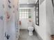 Bathroom featuring a decorative shower curtain, tiled floor and glass block window at 110 N Brown Ave, Orlando, FL 32801