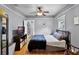 A cozy bedroom with a ceiling fan, a window, light-colored walls and hardwood floors at 110 N Brown Ave, Orlando, FL 32801