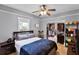 Cozy bedroom with a ceiling fan, a large window, hardwood floors, and a walk-in closet at 110 N Brown Ave, Orlando, FL 32801
