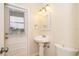 Bathroom features a pedestal sink, toilet, lighting fixture, and a door to the backyard at 13524 Lake Luntz Dr, Winter Garden, FL 34787