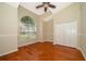 Bedroom with hardwood flooring, a large arched window, closet, and neutral paint at 13524 Lake Luntz Dr, Winter Garden, FL 34787