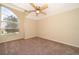 Bedroom with carpet flooring and ceiling fan, featuring a large arched window at 13524 Lake Luntz Dr, Winter Garden, FL 34787