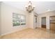 Bright dining room featuring tile floors, a modern chandelier, and large window with backyard view at 13524 Lake Luntz Dr, Winter Garden, FL 34787
